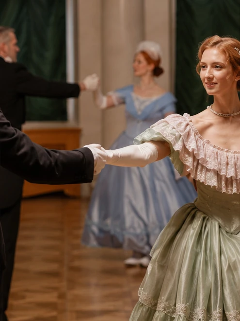 Mehrere Tanzpaare in historischer Kleidung bei einem Ball